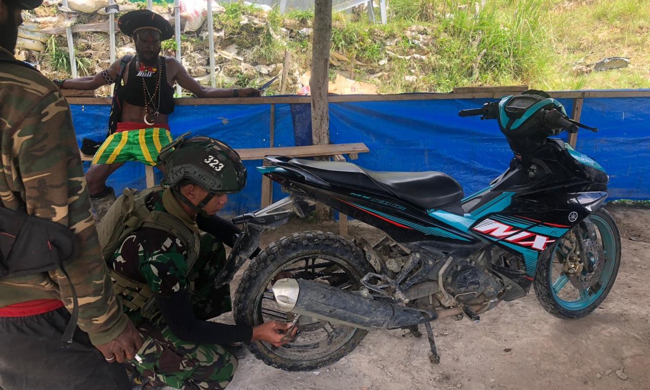 berikan konstribusi nyata, prajurit Yonif 323 Buaya Putih Kostrad memberikan pelayanan servis kerusakan pada kendaraan bermotor warga